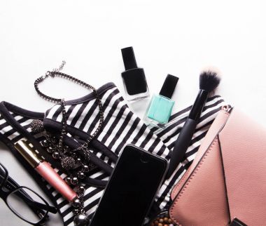 Gözlükleri, temeli, dudak parlatıcısı, pudrası, fırçası, el çantası, çizgili gömleği olan stilize kadın bezi.