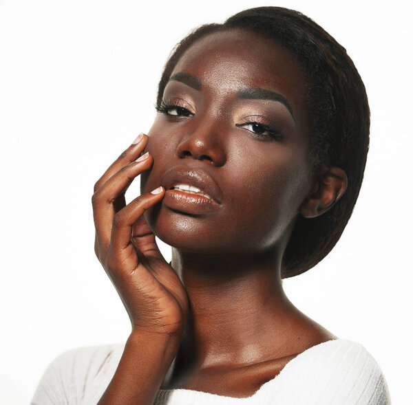 Beautiful black woman posing in a studio over white background