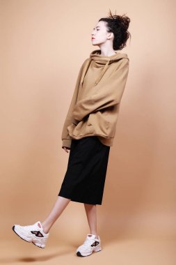 Genç esmer model stüdyoda poz veriyor, bej arka plan