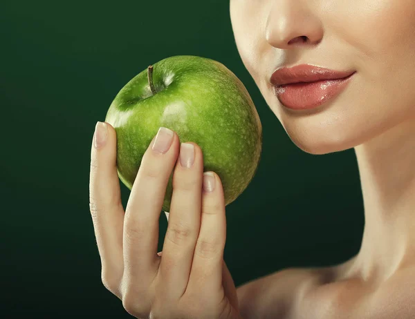 녹색 배경 위에 초록색 사과를 든 젊은 여자 — 스톡 사진