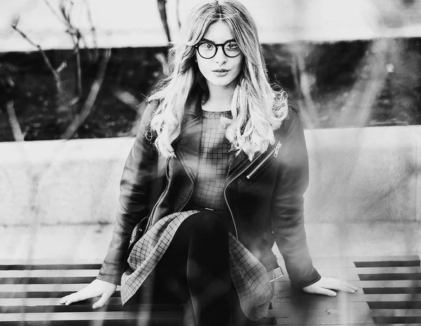 Blonde gir sits on a bench, summer city, black and white picture — Stock Photo, Image