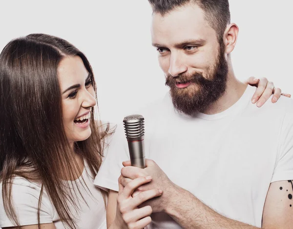 Estilo de vida e conceito de pessoas: Casal jovem com microfone — Fotografia de Stock