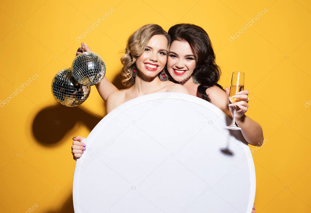 beautiful young women with wine glasses and disco ball.