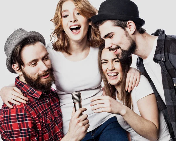 Portrait of happy girls and guys singing in microphone over white background. — Stock Photo, Image