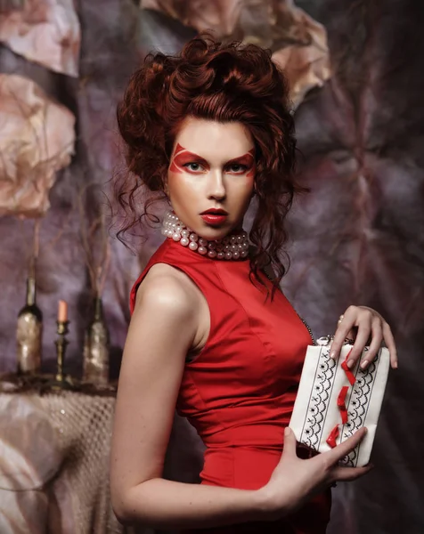 Красивая стильная брюнетка в красном платье держит сумочку — стоковое фото