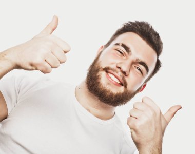 Beyaz arka planda izole edilmiş iyi bir hareket gösteren neşeli, sakallı genç bir adamın portresi.
