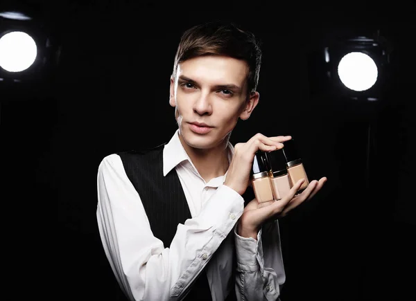 Joven maquillador masculino posando con base para maquillaje o — Foto de Stock