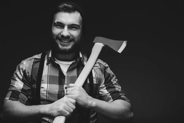 Bearded man with axe posing over black background in studio — Stock Photo, Image