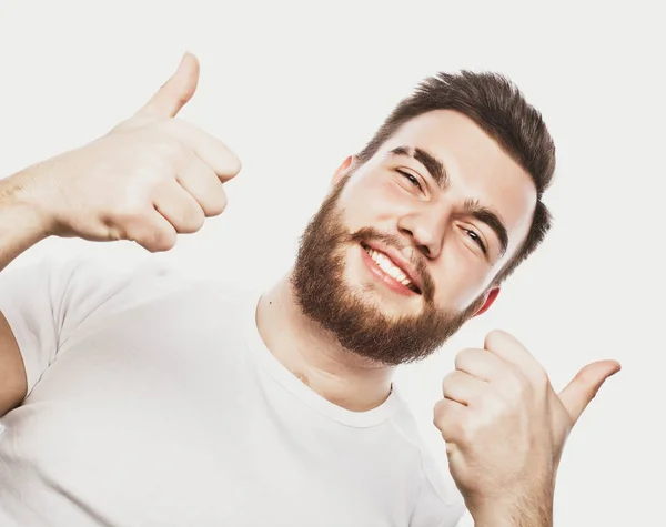 Portrét veselého mladého vousatého muže ukazující v pořádku gesto izolované na bílém pozadí — Stock fotografie
