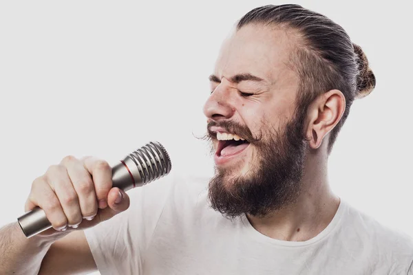 L'animateur. Jeune homme parlant tenant un microphone, isolé sur fond blanc. — Photo