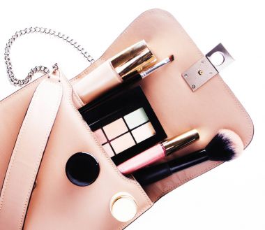 Beyaz arkaplanda kozmetik çantalı makyaj ürünleri