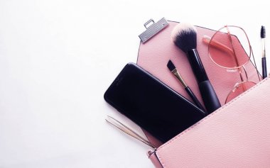Kozmetik ürünler ve Acce ile açılmış pembe deri kadın çantası.