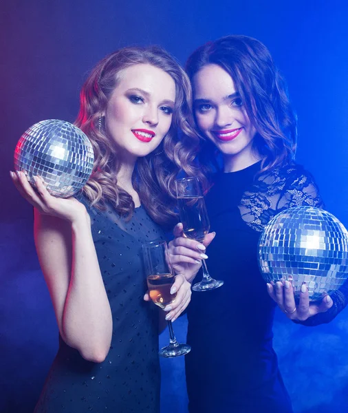 Estilo de vida y el concepto de la gente: dos hermosas mujeres con copas de vino y bola disco, tiempo de fiesta — Foto de Stock