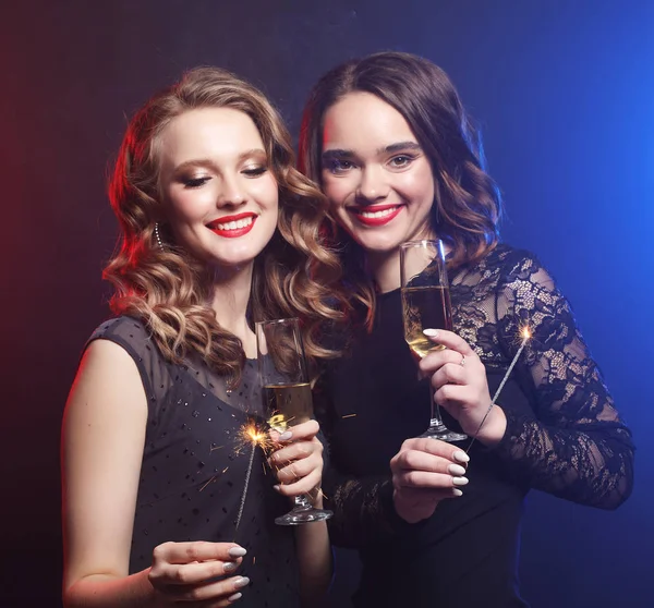 Hora da festa. Duas belas mulheres jovens com copos de vinho e spar — Fotografia de Stock