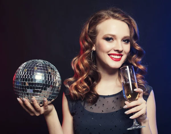 Giovane donna che tiene un bicchiere di vino e discoteca palla al night club — Foto Stock