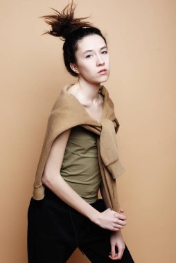 yaşam tarzı ve moda kavramı: bej renkli arka plan üzerinde poz rahat kıyafetler giymiş esmer kadın