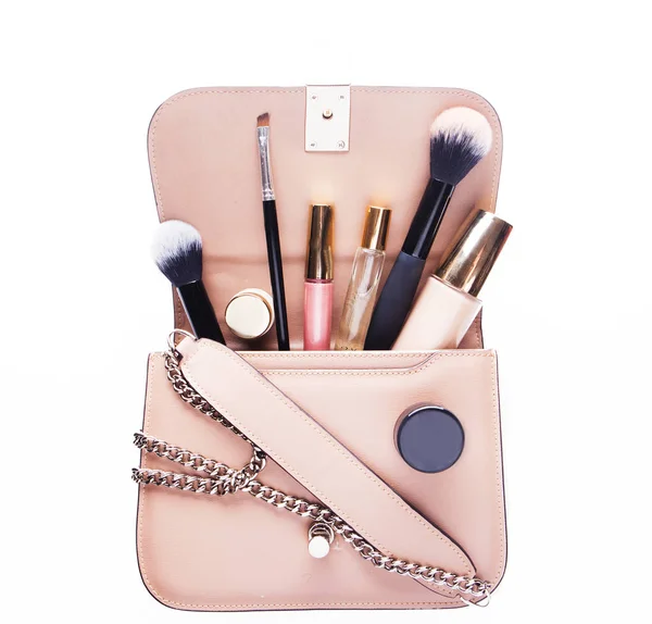 Concept de mode : Pose plate de sac femme en cuir rose ouvert avec des cosmétiques et accessoires sur fond blanc. — Photo