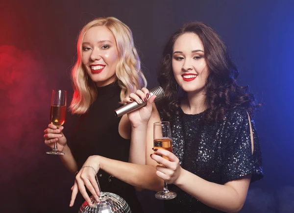 Koncepcja stylu życia i ludzi: dwie piękne młode kobiety w kieliszkach do wina i dyskotece — Zdjęcie stockowe