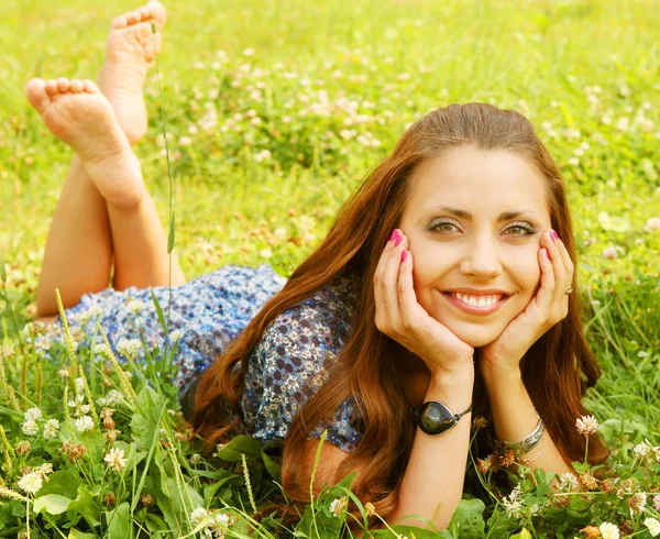 Young beautiful girl lays on a grass — Stock Photo, Image