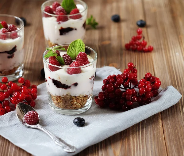 Fröhliches Frühstück - Joghurt mit Müsli und Beeren auf einem Holztisch — Stockfoto