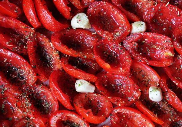 Domates bir fırın tepsisine pişirmeye hazır yalan. Kurutulmuş domates sarımsak ile. — Stok fotoğraf