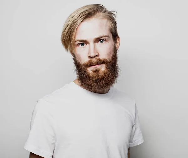 Portret van een jonge man met baard in een wit t-shirt — Stockfoto