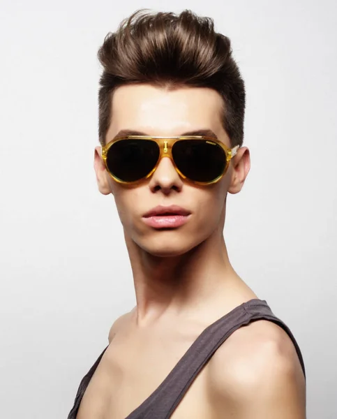 Moda tarzında güneş gözlüğü takan seksi genç adam. Erkek modeli. — Stok fotoğraf