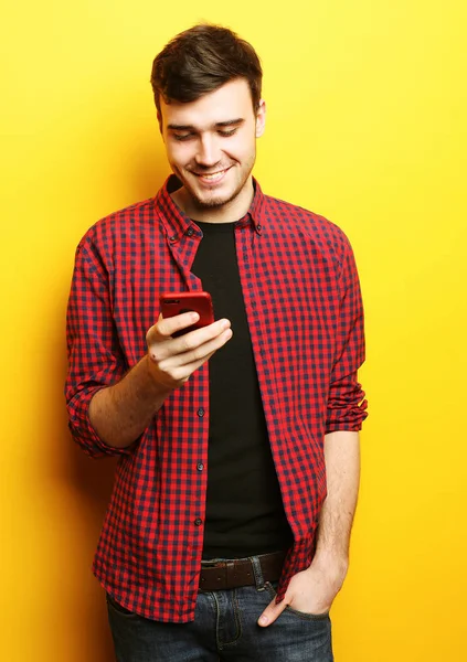 Glücklicher junger Mann telefoniert auf gelbem Hintergrund — Stockfoto