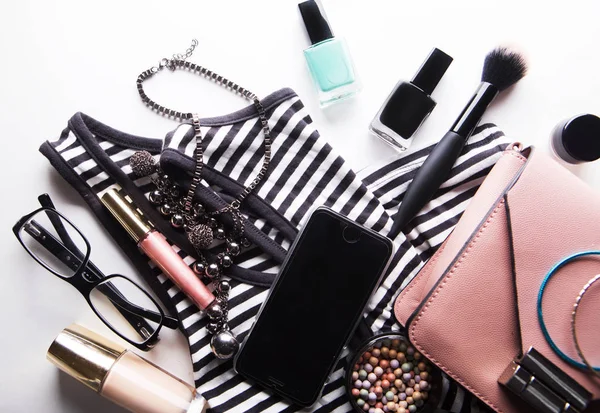 Lapos laikus rózsaszín bőr nő táska kozmetikumok, kiegészítők és okostelefon fehér alapon — Stock Fotó