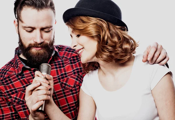 Happy couple singing in karaoke over white background,