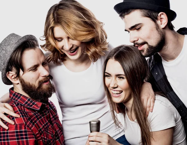 Retrato de meninas felizes e caras cantando em microfone sobre fundo branco . — Fotografia de Stock