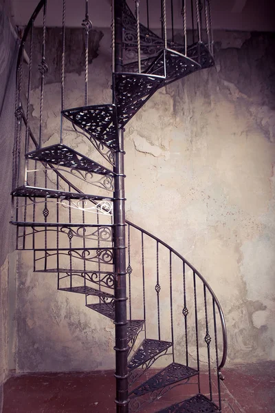 Metal spiral staircase against the old wall background — Stock Photo, Image