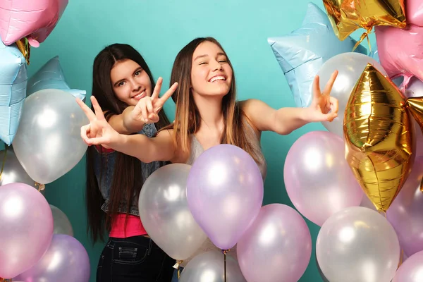 Estilo de vida y el concepto de la gente: dos amigas con globos aerostáticos de colores - jóvenes y felices. —  Fotos de Stock