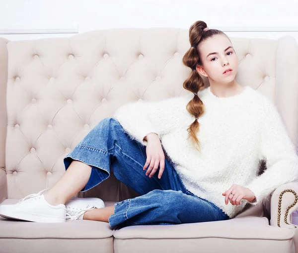 Stilvolles Teenie-Mädchen in lässiger Kleidung sitzt auf dem Sofa und posiert — Stockfoto
