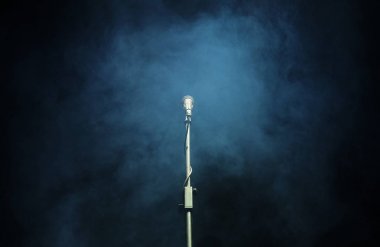 Koyu arkaplanda bir duman içinde mikrofon