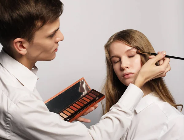 Maquillar artista haciendo profesional maquillaje de mujer joven — Foto de Stock