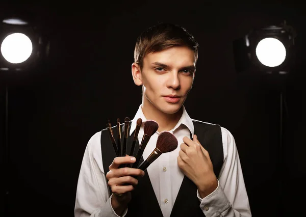 Young male make up artist posing with make-up brushes — Stock Photo, Image