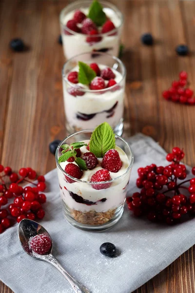 Desayuno saludable yogur con bayas frescas y muesli servido en frasco de vidrio, sobre fondo de madera —  Fotos de Stock