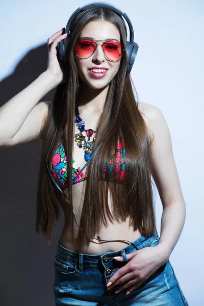 白い背景の上モデルのヘッドフォン マイクを着て女の子ピンク水着 — ストック写真