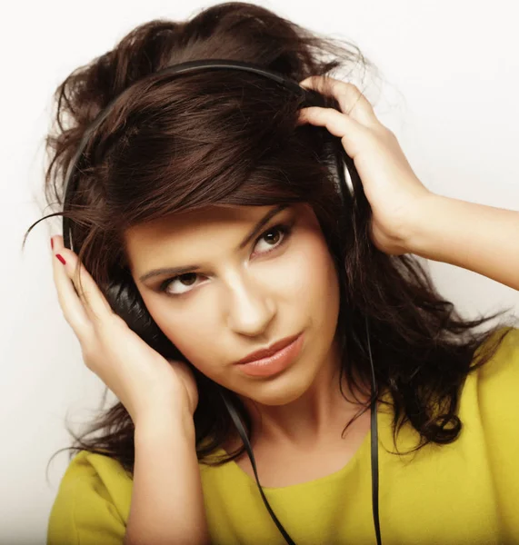 Kvinna med hörlurar lyssnar musik. Musik flicka dans mot vit bakgrund. — Stockfoto