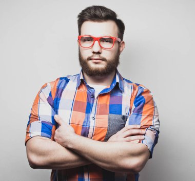 Yaşam tarzı ve insan konsepti: Genç sakallı adam beyaz arka planda kollarını kavuşturuyor