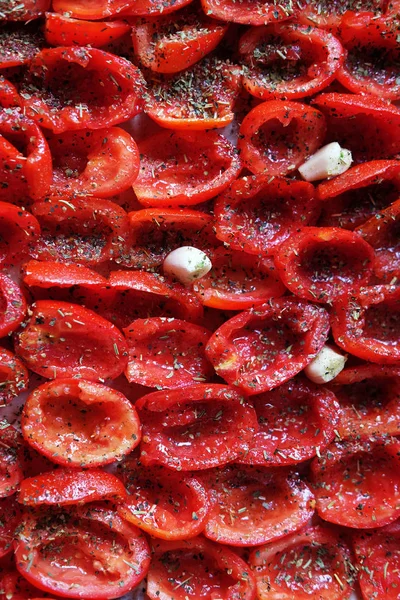 Domates bir fırın tepsisine pişirmeye hazır yalan. Kurutulmuş domates sarımsak ile. Gıda arka plan. Yakın çekim — Stok fotoğraf