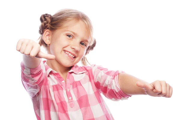 Snímek šťastné malé dítě dívka stojící izolované na bílém pozadí. Při pohledu kamery ukazuje palec. — Stock fotografie