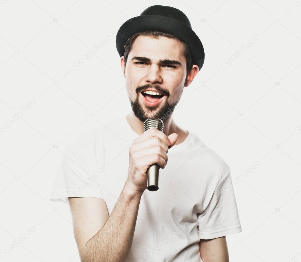  Image of a handsome man singing to the microphone.