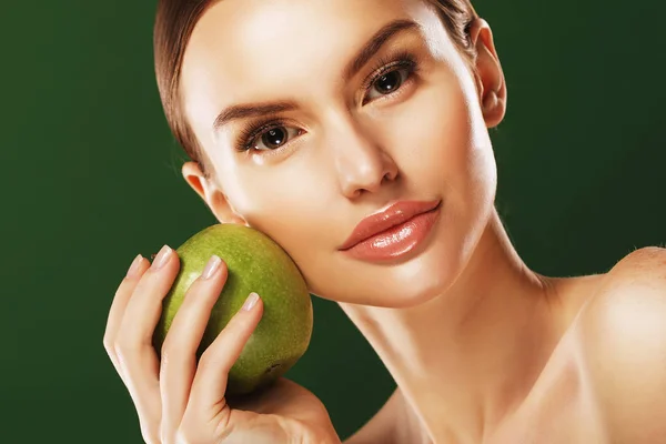 Mujer joven con manzana verde sobre fondo verde — Foto de Stock