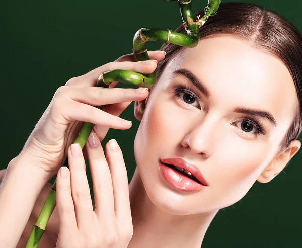 Hermosa mujer con bambú aislado sobre fondo verde — Foto de Stock