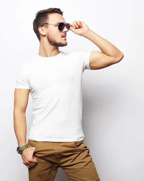 Elegante joven guapo manin ropa casual inteligente y gafas de sol. — Foto de Stock