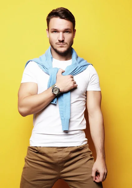 Handsome young man, fashion model. Posing over yellow wall. Lifestyle and fashion concept. — Stock Photo, Image