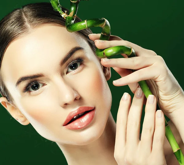 Hermosa mujer con bambú aislado sobre fondo verde — Foto de Stock