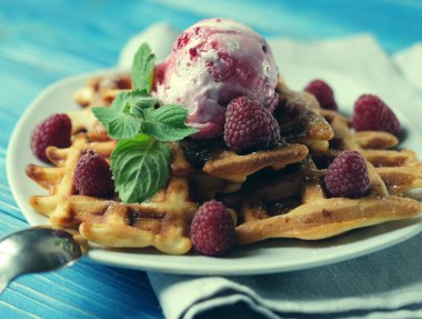 Dondurma ve mavi ahşap arka plan üzerinde taze çilek ile Belçika waffle tabak
